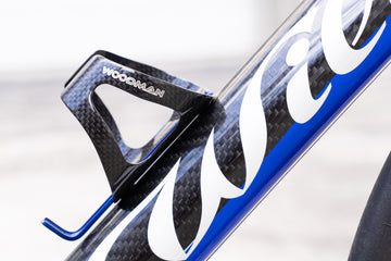 Carbon water bottle cage featuring blue holder and 3K black design